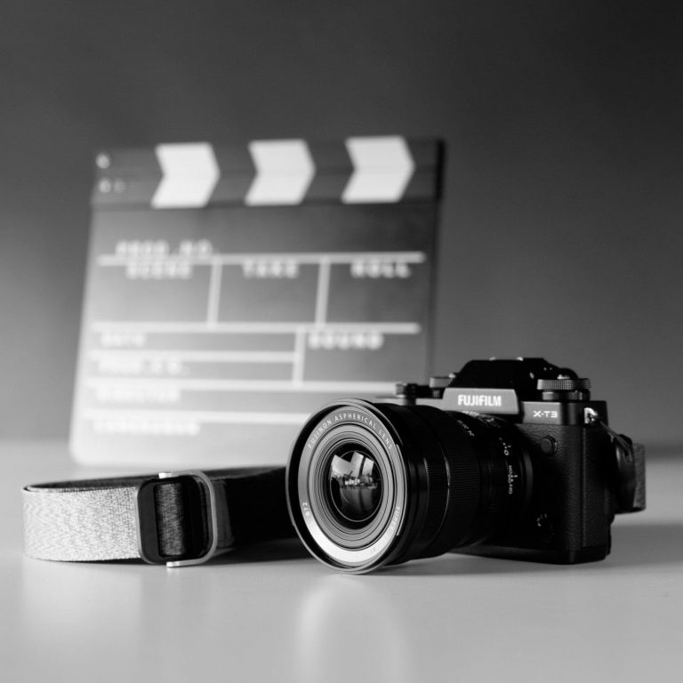 Kamera und Filmklappe in schwarz-weiß auf einem Tisch