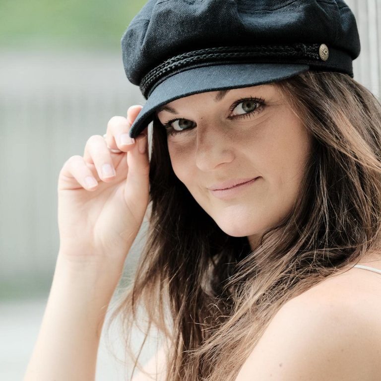 Portraitfoto einer jungen Frau mit Mütze