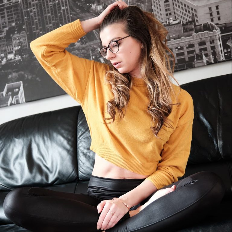 Beispielbild aus einem Fashionshooting mit einem Model mit  auffällig gelbem Top auf einem Sofa