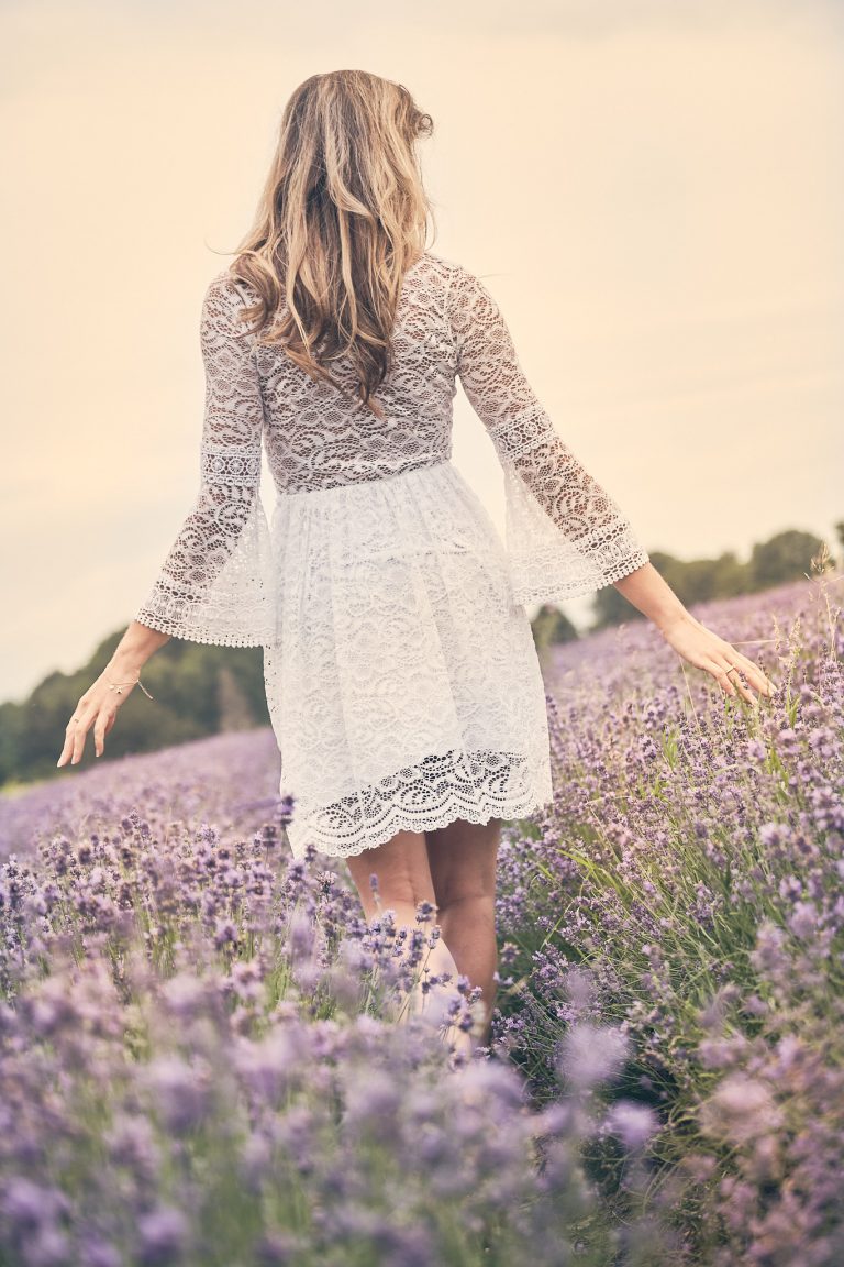 Model mit kurzem weißem Kleid im Lavendelfeld
